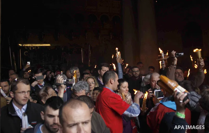 Christian Orthodox worshipers hold up candles lit from the "Holy Fire" as thousands gather in the Church of the Holy Sepulchre in Jerusalem's Old City, on April 11, 2015 during the Orthodox Easter ceremony of the "Holy F...