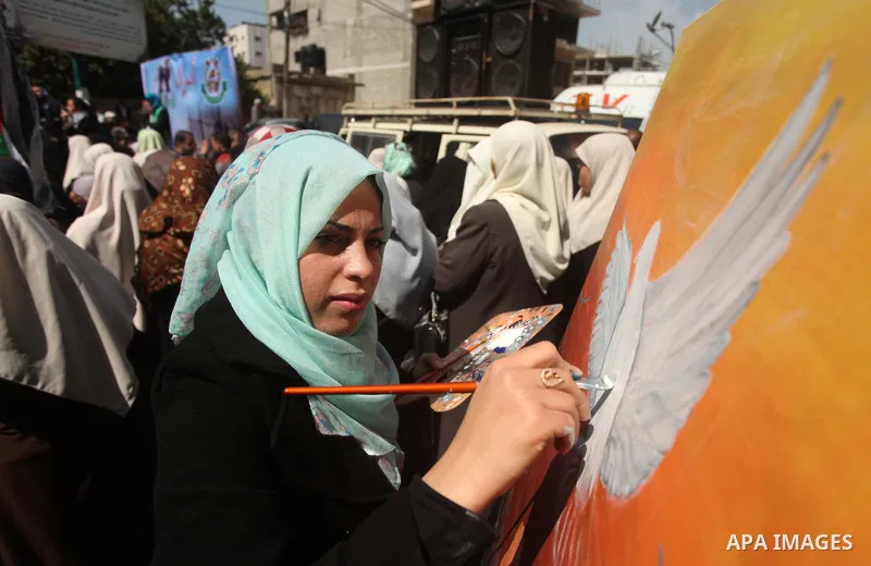 A Palestinians artist paints artwork during a protest calling for the release of Palestinian prisoners held in Israeli jails, outside the International Red Cross offices in Gaza City, on April 13, 2015. Photo by Ashraf A...