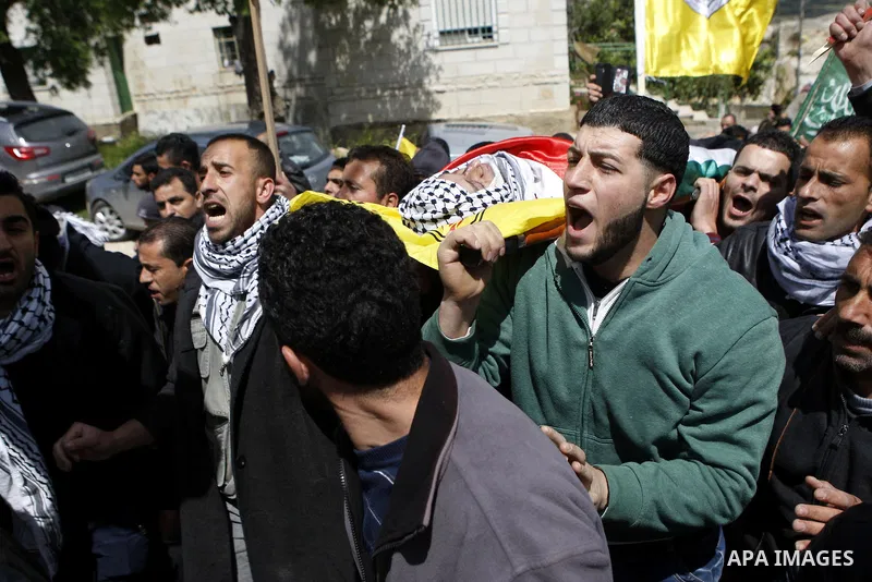 Mourners carry the body of 27-year-old Palestinian Mohammed Jasser Karakra, during his funeral in the Sinjil village, in the occupied West Bank city of Ramallah, on April 13, 2015. Karakra stabbed two Israeli soldiers in...