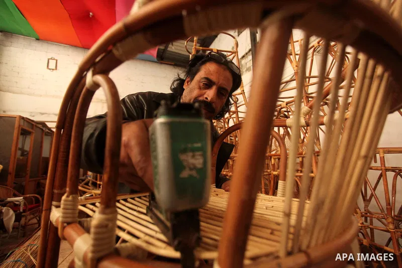 A Palestinian man works on bamboo furniture at his workshop in Gaza city on April 16, 2015. Bamboo is a product of southeast Asian countries and before the Israeli blockade of the Gaza Strip, Gaza traders used to bring i...