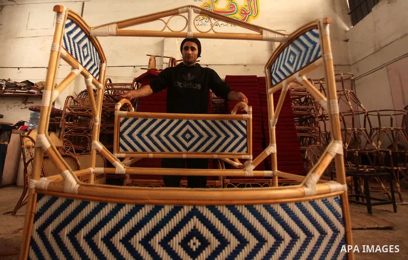 A Palestinian man works on bamboo furniture at his workshop in Gaza city on April 16, 2015. Bamboo is a product of southeast Asian countries and before the Israeli blockade of the Gaza Strip, Gaza traders used to bring i...
