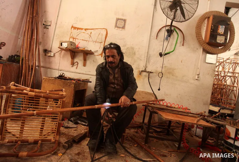 A Palestinian man works on bamboo furniture at his workshop in Gaza city on April 16, 2015. Bamboo is a product of southeast Asian countries and before the Israeli blockade of the Gaza Strip, Gaza traders used to bring i...