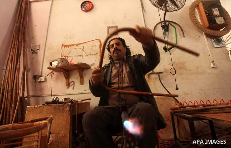 A Palestinian man works on bamboo furniture at his workshop in Gaza city on April 16, 2015. Bamboo is a product of southeast Asian countries and before the Israeli blockade of the Gaza Strip, Gaza traders used to bring i...