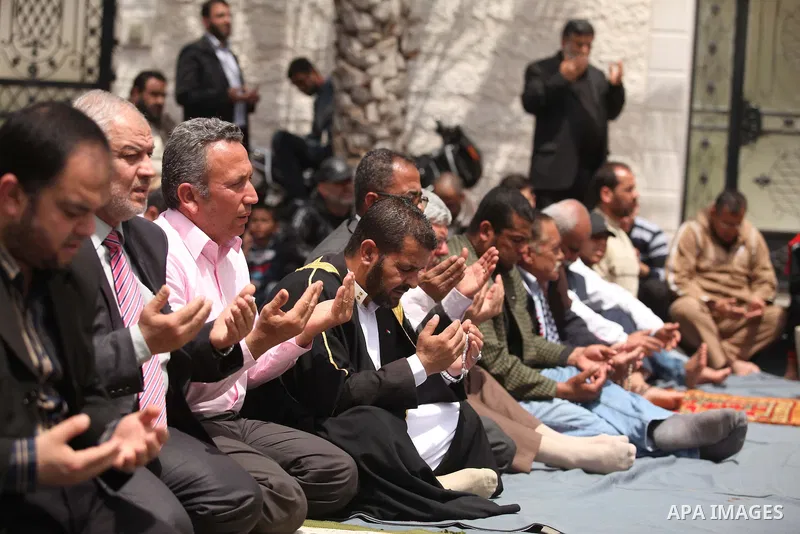 Palestinians take part in Friday prayer outside the headquarters of the High Commissioner for Human Rights in protest to mark the prisoners' day, in Gaza city on April 17, 2015. Photo by Ashraf Amra