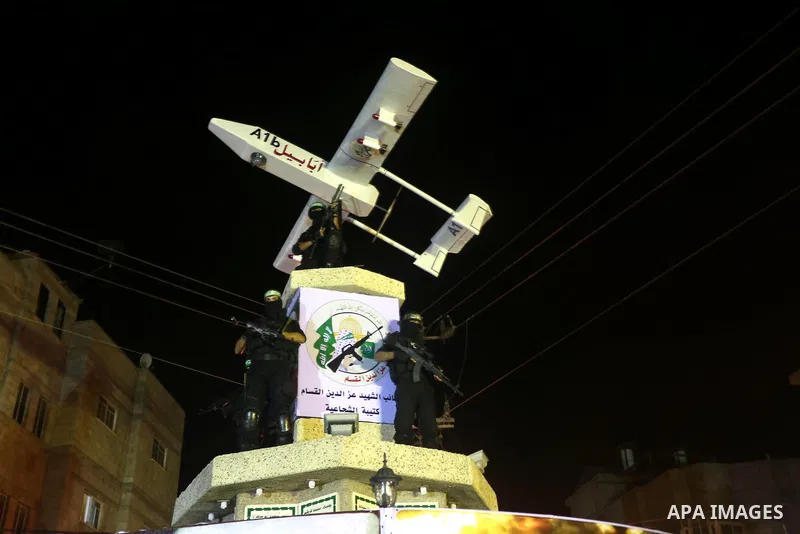 Palestinian members of al-Qassam Brigades stand near a model of a Hamas manufactored A1b drone, during a ceremony marking the eleventh anniversary of the death of former Hamas leader Abdel Aziz al-Rantissi, in the easter...
