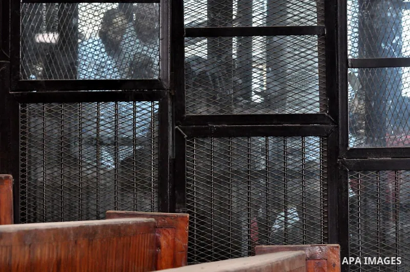 Members of Ansar Bayt al-Maqdis stand behind bars at a courtroom, during their trial in Cairo on April 18, 2015. 213 defendant members of Ansar al-Bayt al-Maqdis, including 140 defendants locked up, for committing a crim...