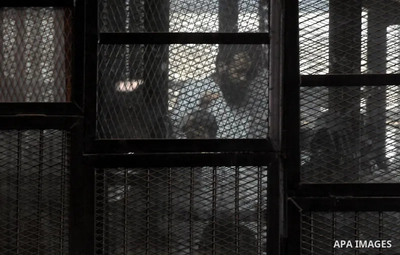 Members of Ansar Bayt al-Maqdis stand behind bars at a courtroom, during their trial in Cairo on April 18, 2015. 213 defendant members of Ansar al-Bayt al-Maqdis, including 140 defendants locked up, for committing a crim...