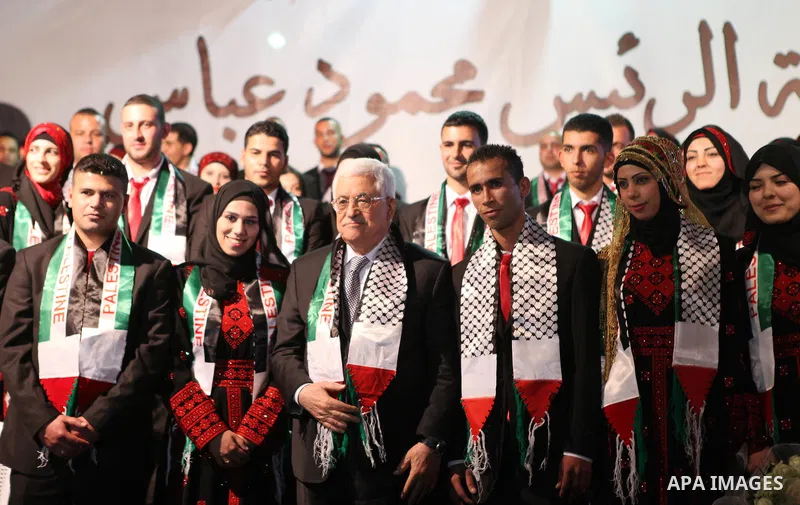 President Mahmoud Abbas poses for a photograph with Palestinian couples during the national mass wedding ceremony, in the West Bank city of Jericho, April 20, 2015. Nearly 462 Palestinian couples were married in a ceremo...