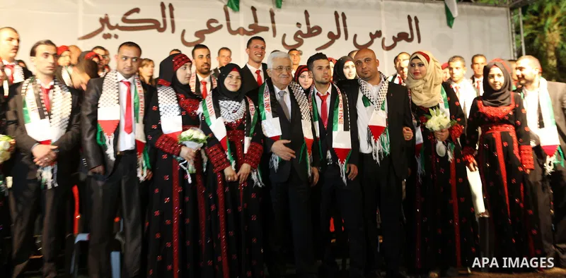 President Mahmoud Abbas poses for a photograph with Palestinian couples during the national mass wedding ceremony, in the West Bank city of Jericho, April 20, 2015. Nearly 462 Palestinian couples were married in a ceremo...