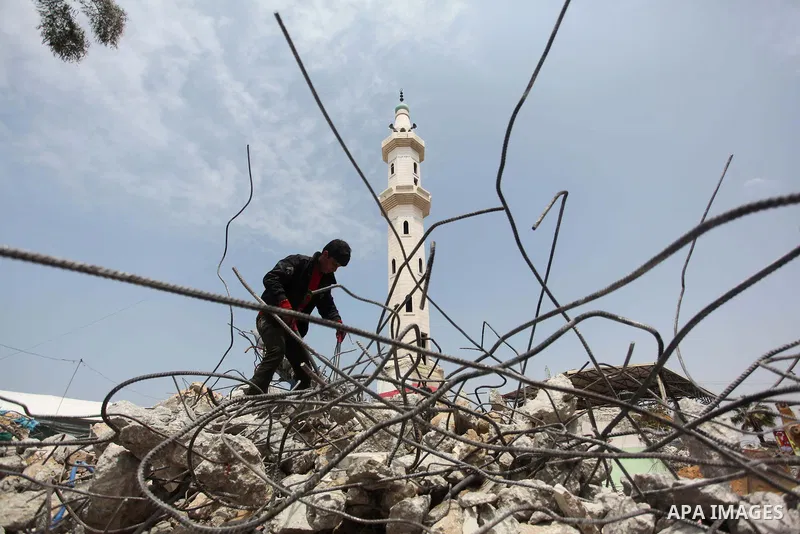 A Palestinian worker collects iron bars from the rubbles of houses, that witnesses said were destroyed by Israeli shelling during the 50-day Israeli war in the summer of 2014, in Gaza city on April 22, 2015. According to...