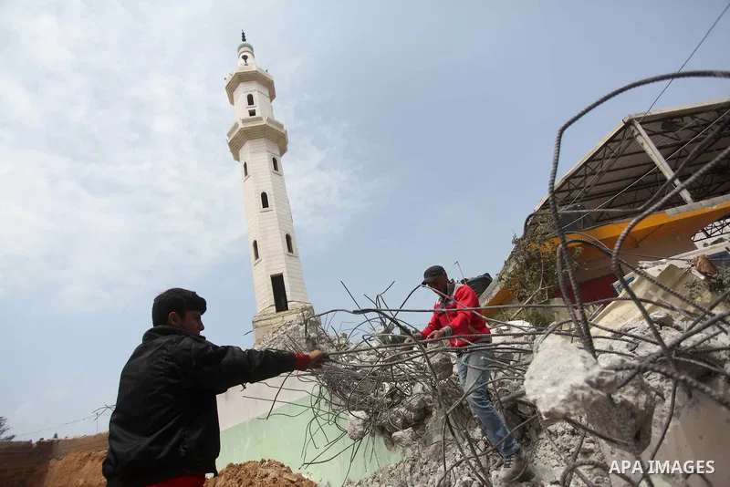 Palestinian workers collect iron bars from the rubbles of houses, that witnesses said were destroyed by Israeli shelling during the 50-day Israeli war in the summer of 2014, in Gaza city on April 22, 2015. According to a...