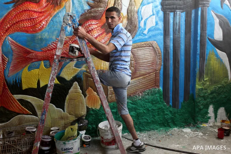 Palestinian artist Jihad Al-Ghoul, 23, works at his house in Bureij refugee camp in the center Gaza Strip, on April 25, 2015. Al-Ghoul said that he lost his leg in an Israeli attacked on Bureij refugee camp in 2008. Phot...