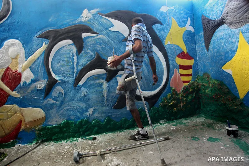 Palestinian artist Jihad Al-Ghoul, 23, works at his house in Bureij refugee camp in the center Gaza Strip, on April 25, 2015. Al-Ghoul said that he lost his leg in an Israeli attacked on Bureij refugee camp in 2008. Phot...