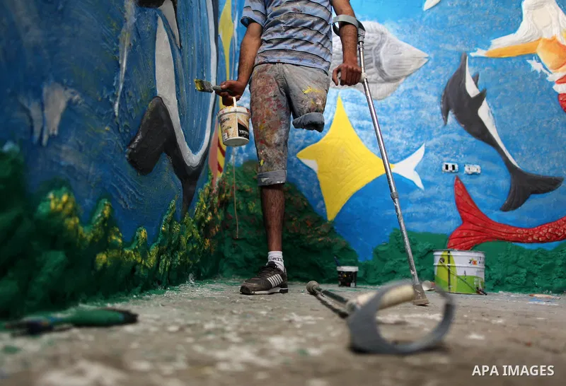 Palestinian artist Jihad Al-Ghoul, 23, works at his house in Bureij refugee camp in the center Gaza Strip, on April 25, 2015. Al-Ghoul said that he lost his leg in an Israeli attacked on Bureij refugee camp in 2008. Phot...
