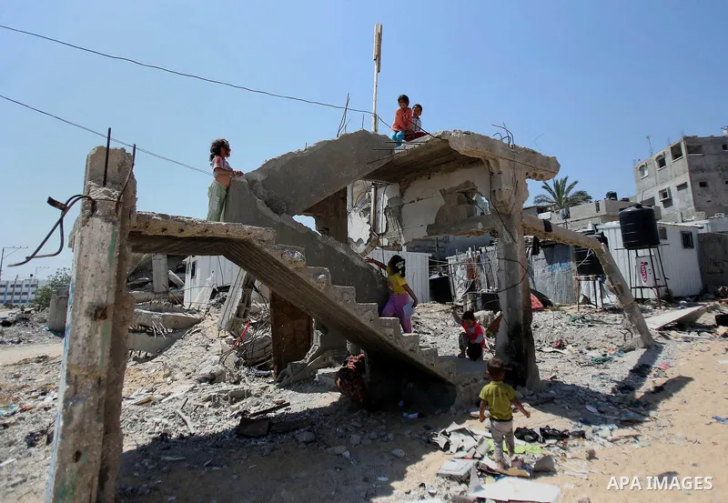 Palestinian children play on the rubble of their family house which destroyed during the 50-day war between Israel and Hamas militants in the summer of 2014, in Beit Lahiya in the northern Gaza Strip on April 26, 2015. P...