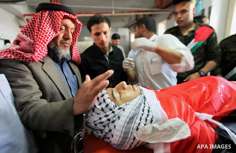Palestinian relatives of Muhammad Yahiya, 18, gather around his body at a morgue of the Rafidia Governmental Hospital in the West Bank city of April 28, 2015. Yahiya died from injuries sustained during clashes with Israe...