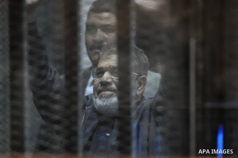 Egyptian President, Mohammad Morsi, stands behind bars as his trial on charges of espionage continues, Cairo, Egypt, 28 April 2015. Morsi has been charged along with several others of leaking classified documents while P...