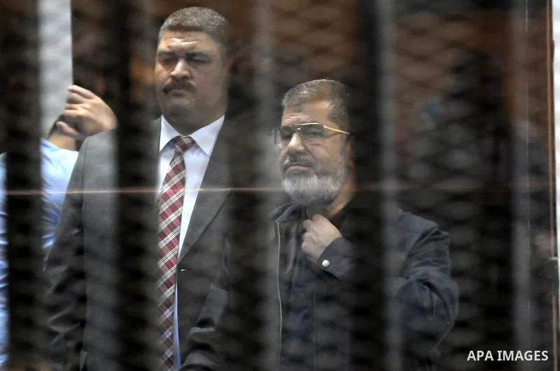 Egyptian President, Mohammad Morsi, stands behind bars as his trial on charges of espionage continues, Cairo, Egypt, 28 April 2015. Morsi has been charged along with several others of leaking classified documents while P...