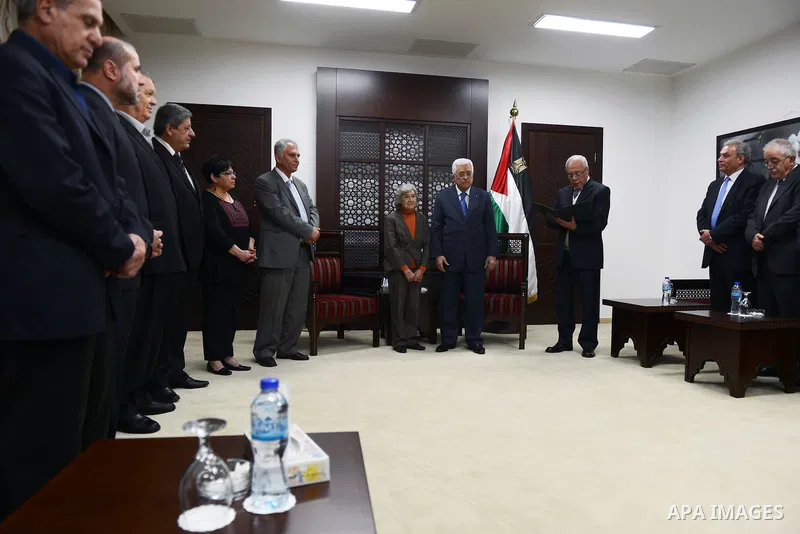 President Mahmoud Abbas honors the wife of former Palestinian poet Moieen Bsaisu, at Abbas's headquarter, in the West Bank city of Ramallah, April 28, 2015. Photo by Thaer Ganaim