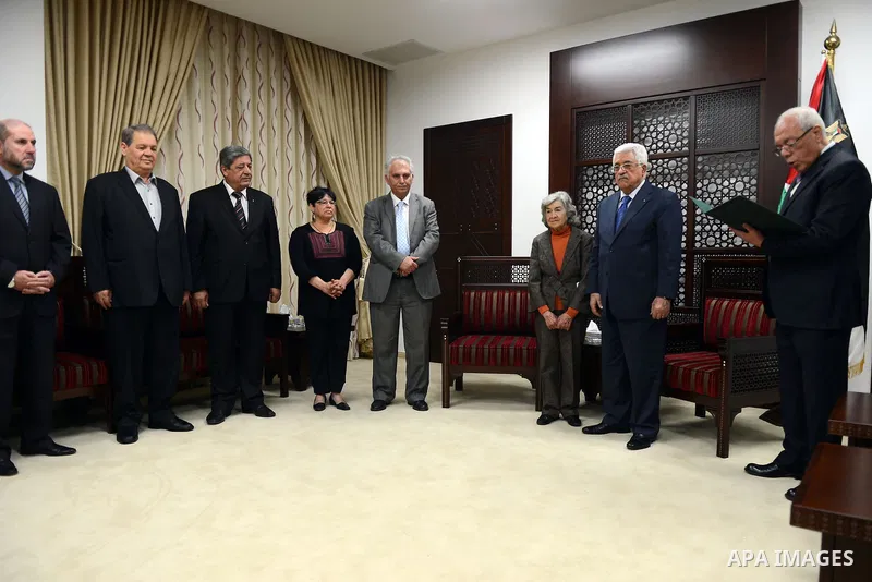 President Mahmoud Abbas honors the wife of former Palestinian poet Moieen Bsaisu, at Abbas's headquarter, in the West Bank city of Ramallah, April 28, 2015. Photo by Thaer Ganaim