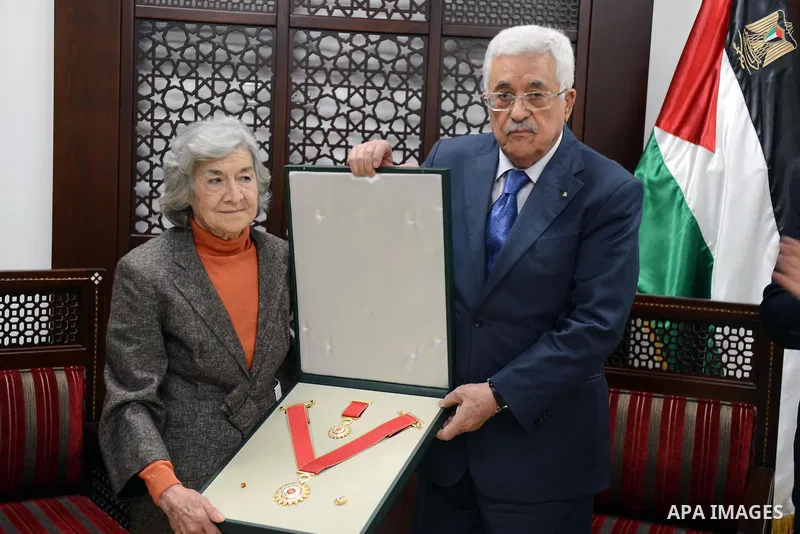 President Mahmoud Abbas honors the wife of former Palestinian poet Moieen Bsaisu, at Abbas's headquarter, in the West Bank city of Ramallah, April 28, 2015. Photo by Thaer Ganaim