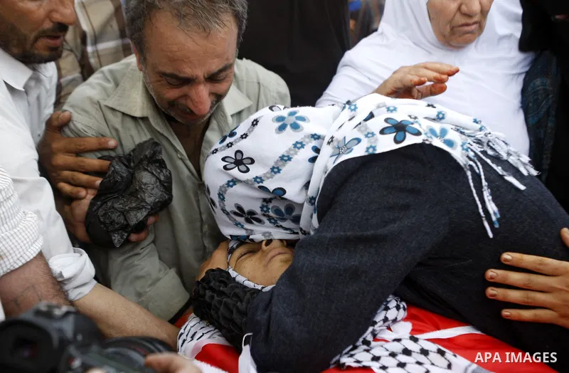 Relatives mourn over the body of Palestinian Mohammad Saleh, 18, during his funeral in the West Bank village of Alaraqa near Jenin April 28, 2015. Saleh shot by Israeli soldiers in the occupied West Bank died of his woun...