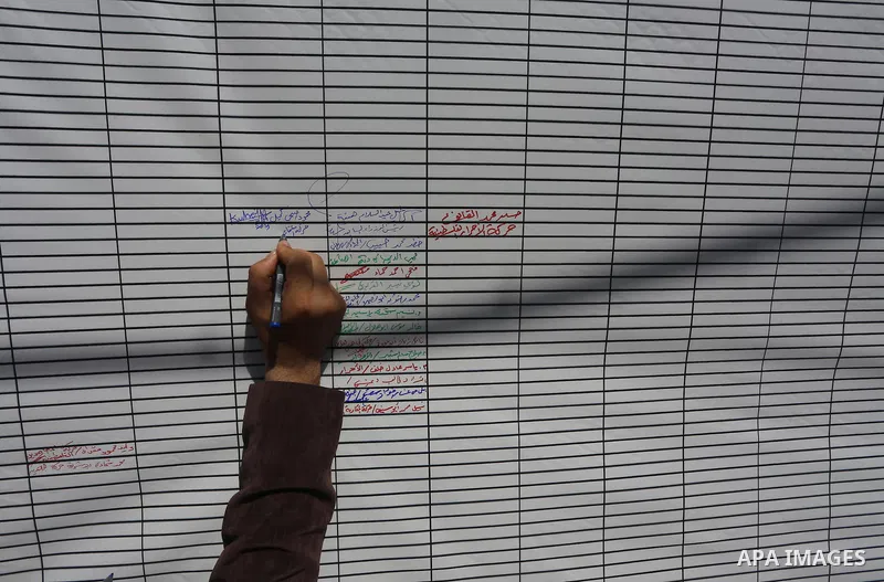 A Palestinian man signs a symbolic document against Israel's settlements and separation barrier in the Palestinian Authority-controlled West Bank, on April 29, 2015 in Gaza City. Photo by Mohammed Asad