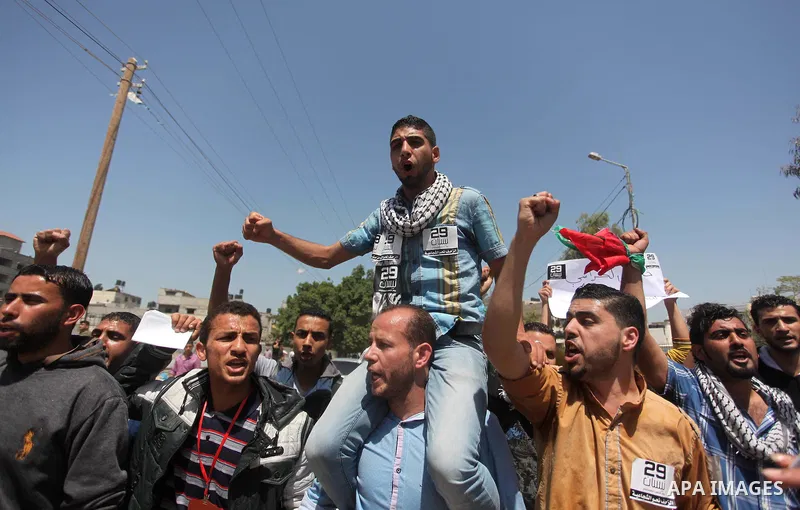Palestinian youths chant slogans during a protest calling for an end in the political division and opening the Rafah crossing border, in Gaza city, on April 29, 2015. Photo by Ashraf Amra