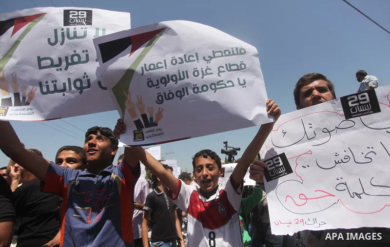 Palestinian youths chant slogans during a protest calling for an end in the political division and opening the Rafah crossing border, in Gaza city, on April 29, 2015. Photo by Ashraf Amra
