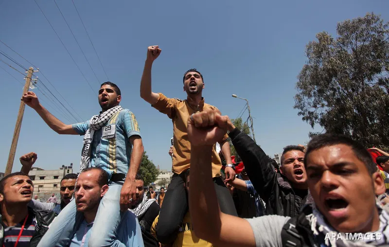 Palestinian youths chant slogans during a protest calling for an end in the political division and opening the Rafah crossing border, in Gaza city, on April 29, 2015. Photo by Ashraf Amra