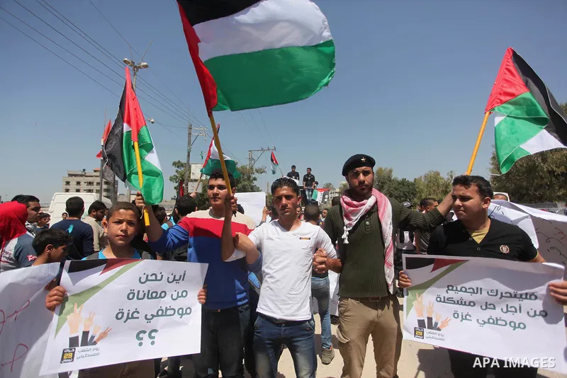 Palestinian youths chant slogans during a protest calling for an end in the political division and opening the Rafah crossing border, in Gaza city, on April 29, 2015. Photo by Ashraf Amra