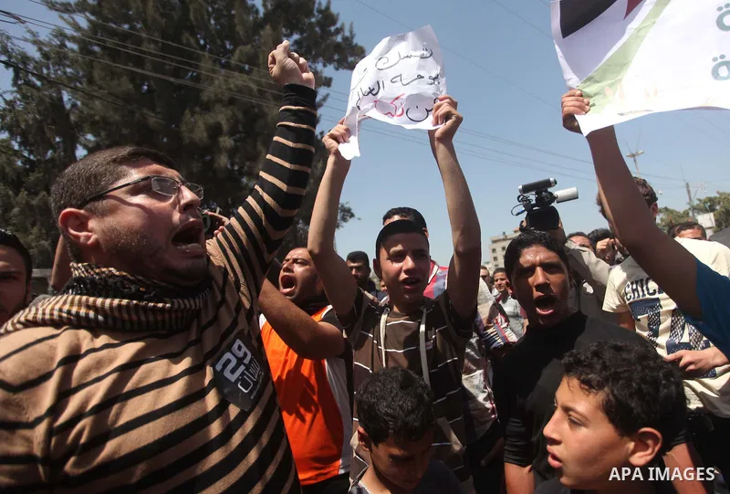 Palestinian youths chant slogans during a protest calling for an end in the political division and opening the Rafah crossing border, in Gaza city, on April 29, 2015. Photo by Ashraf Amra