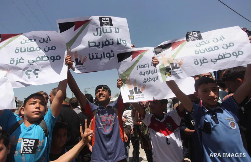 Palestinian youths chant slogans during a protest calling for an end in the political division and opening the Rafah crossing border, in Gaza city, on April 29, 2015. Photo by Ashraf Amra