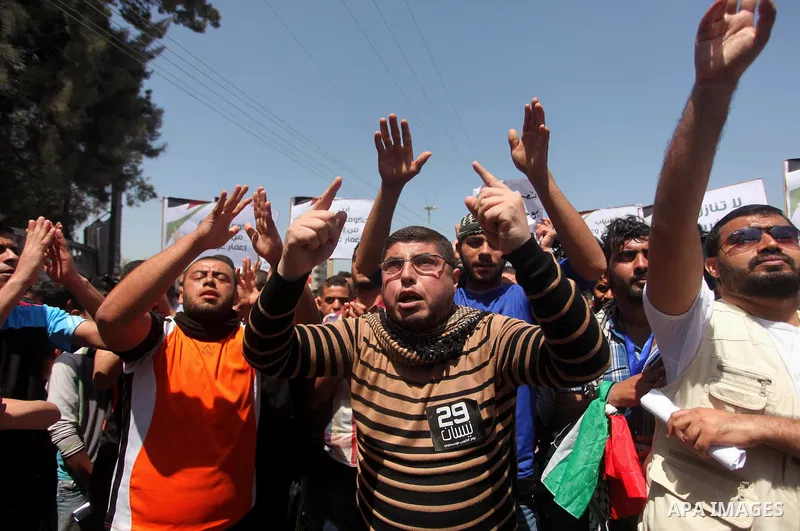 Palestinian youths chant slogans during a protest calling for an end in the political division and opening the Rafah crossing border, in Gaza city, on April 29, 2015. Photo by Ashraf Amra