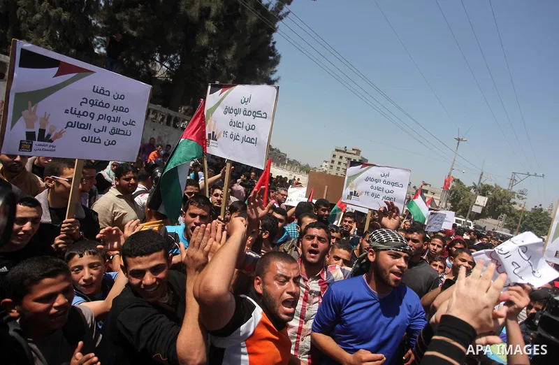 Palestinian youths chant slogans during a protest calling for an end in the political division and opening the Rafah crossing border, in Gaza city, on April 29, 2015. Photo by Ashraf Amra