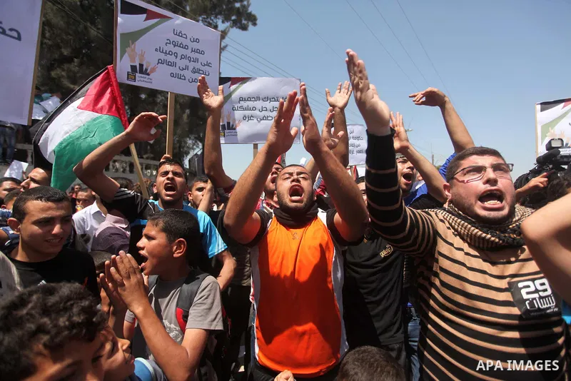 Palestinian youths chant slogans during a protest calling for an end in the political division and opening the Rafah crossing border, in Gaza city, on April 29, 2015. Photo by Ashraf Amra