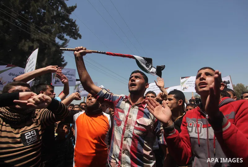 Palestinian youths chant slogans during a protest calling for an end in the political division and opening the Rafah crossing border, in Gaza city, on April 29, 2015. Photo by Ashraf Amra
