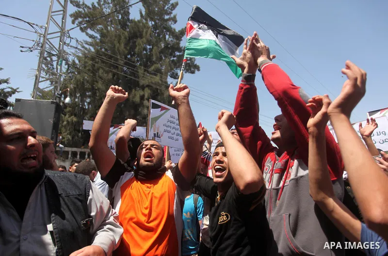 Palestinian youths chant slogans during a protest calling for an end in the political division and opening the Rafah crossing border, in Gaza city, on April 29, 2015. Photo by Ashraf Amra