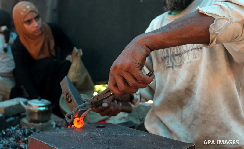 Palestinian blacksmith Ibraheem Mustafa, 40-year-old, hammers heated steel, at his small workshop in Gaza city on April 30, 2015. The ILO estimates that the 2014 conflict in Gaza raised unemployment from 32.6 per cent to...