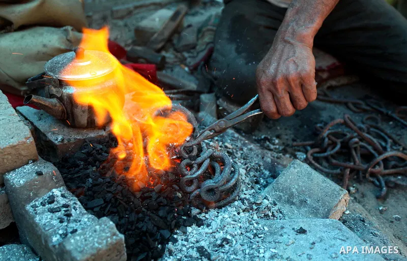 Palestinian blacksmith Ibraheem Mustafa, 40-year-old, melts a steel bar, at his small workshop in Gaza city on April 30, 2015. The ILO estimates that the 2014 conflict in Gaza raised unemployment from 32.6 per cent to 36...