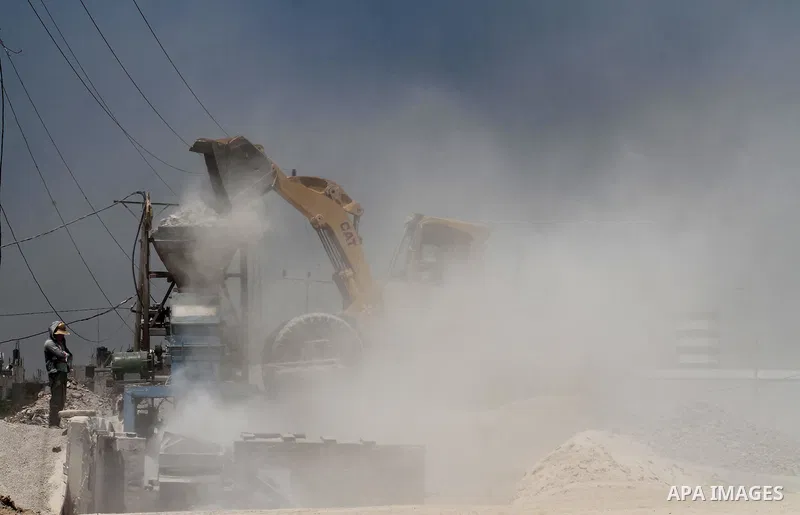 Palestinian workers crush stones and cement blocks from houses destroyed by Israeli shelling during the 50-day Israeli war in the summer of 2014, in the eastern Gaza City neighborhood of Shejaiya on April 30, 2015. The I...