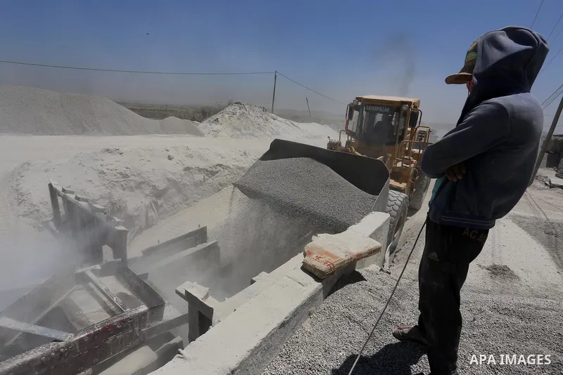 Palestinian workers crush stones and cement blocks from houses destroyed by Israeli shelling during the 50-day Israeli war in the summer of 2014, in the eastern Gaza City neighborhood of Shejaiya on April 30, 2015. The I...