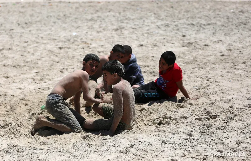 Palestinian children play at the beach of Gaza city on April 30, 2015. Photo by Ashraf Amra