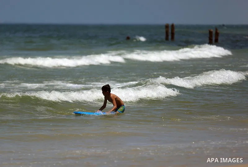 A Palestinian boy swims at the beach of Gaza city on April 30, 2015. Photo by Ashraf Amra