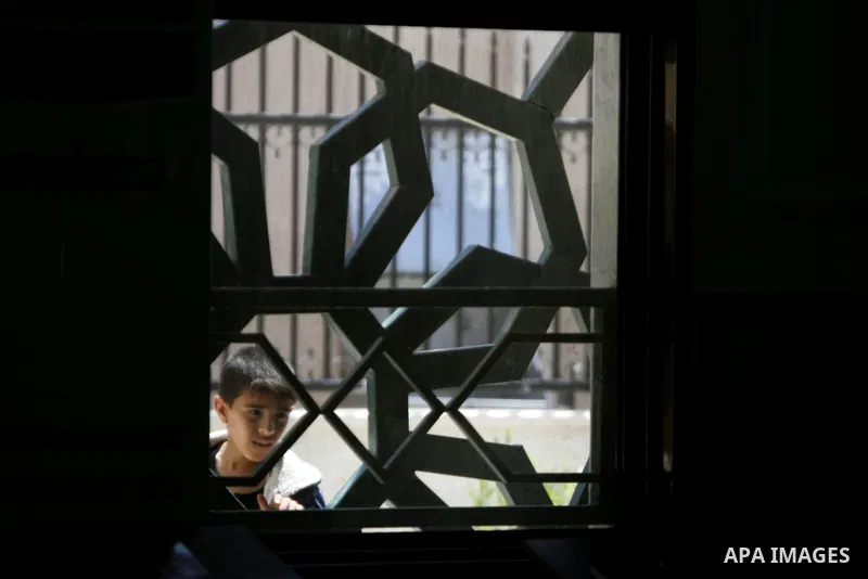 A Palestinian boy looks on as senior Hamas leader Ismail Haniyeh, gives a speech during Friday prayers in the southern Gaza Strip town of Rafah on May 1, 2015. Photo by Abed Rahim Khatib
