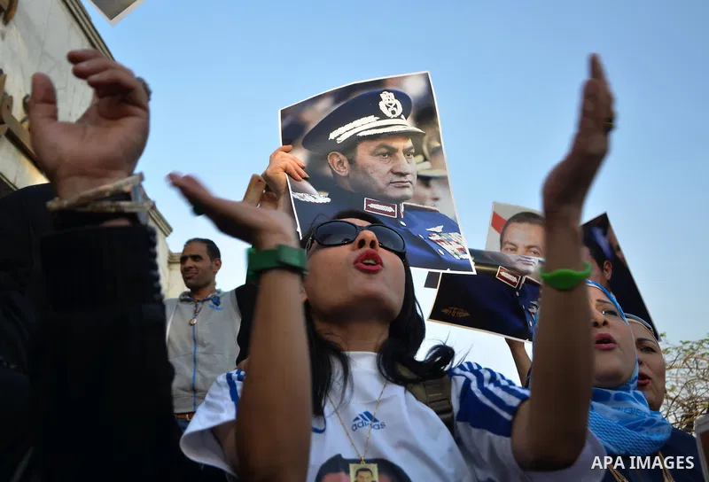 Egyptian supporters of former President Hosni Mubarak hold his picture during a celebration to mark his 87th birthday, outside Maadi military hospital, near Cairo on May 4, 2015. An Egyptian legal authority on Monday rul...