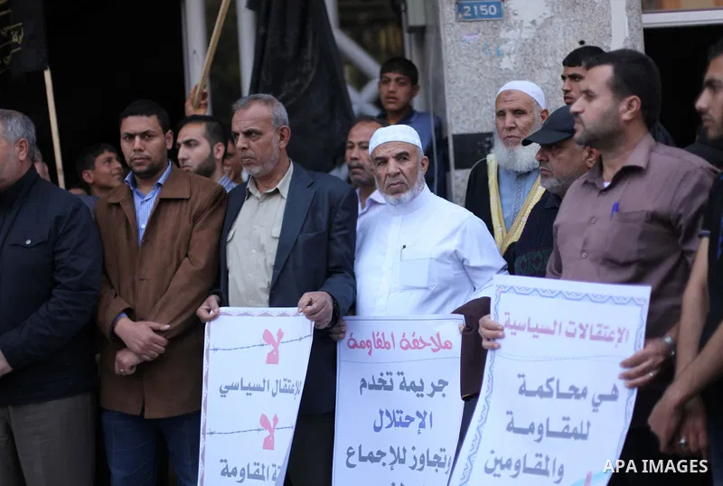 Palestinians hold banners during a protest against the political arrests in the West Bank, in Gaza city on May 5, 2015. Photo by Ashraf Amra