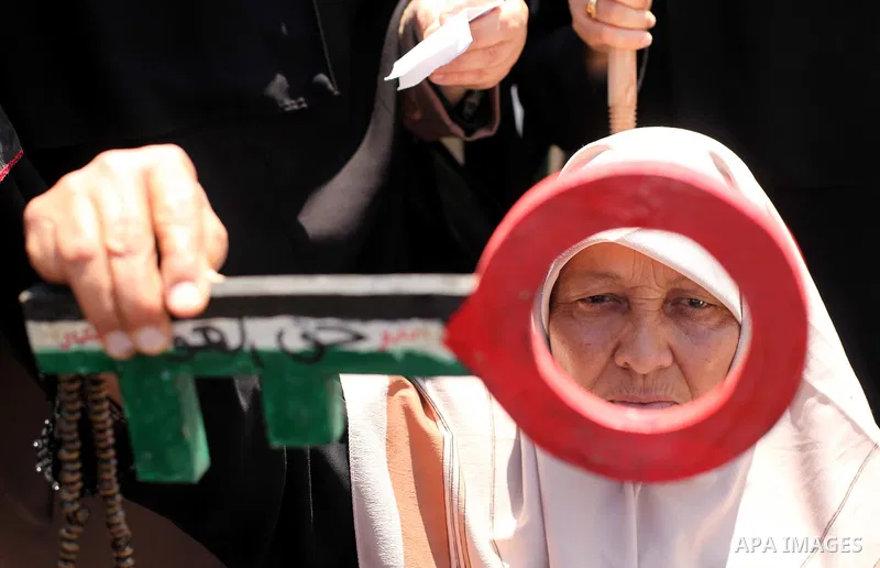 A Palestinian woman, supporter of the Hamas movement, holds a cutout symbolizing a key as she takes part in a demonstration ahead of the commemorations of the 67th anniversary of the "Nakba", in front of the office of th...