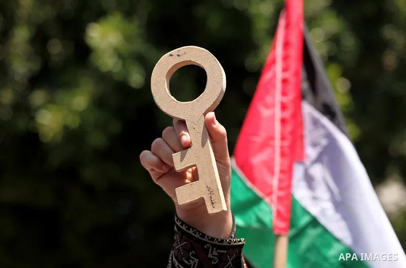 A Palestinian woman, supporter of the Hamas movement, holds a cutout symbolizing a key as she takes part in a demonstration ahead of the commemorations of the 67th anniversary of the "Nakba", in front of the office of th...