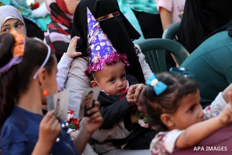 A wife of Palestinian prisoner in Israeli jails, carries her baby, who was born from her husband's smuggled sperm, during a protest demanding visit her husband, outside the Red Cross office, in Gaza city on May 7, 2015....